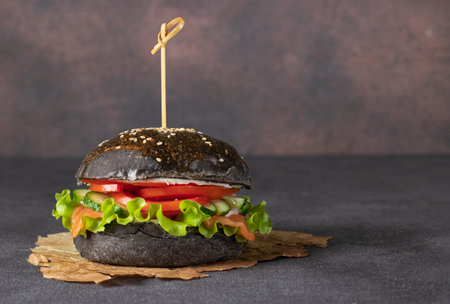 Veggie black burger with salted vegetables on gray backgroundの写真素材