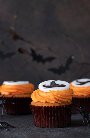 Bright sweet cupcakes with cream for Halloween celebration on brown backgroundの写真素材