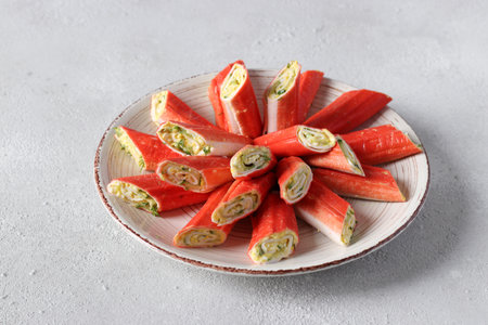 Crab sticks stuffed with cucumber, egg and dill on plate, Festive appetizerの写真素材