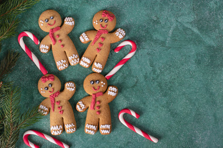 Cookies Gingerbread mans and sweet canes on green new year background, Top view