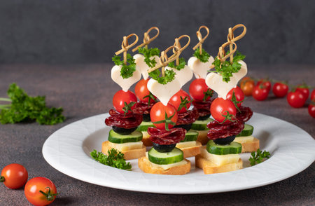 Canape with cheese, cherry tomatoes, sausage and black olivesの写真素材