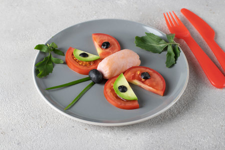Butterfly made from sausage, tomato, avocado and black olives is healthy breakfast idea for kidsの写真素材