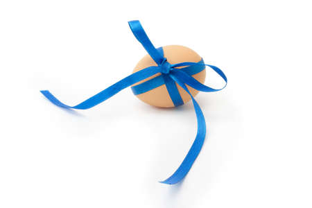 egg with blue ribbon and bow on a white background isolatedの写真素材