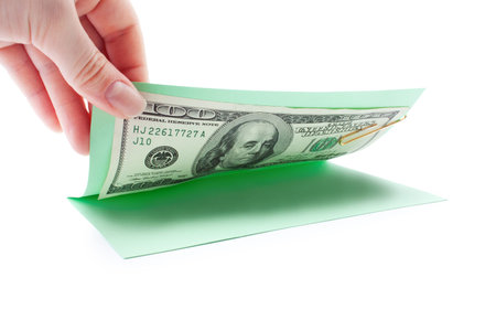 money inside postcard, opening by hand on a white background isolated