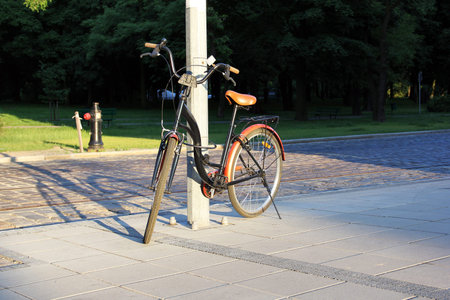 bicycle attached by a cable to a column in the parkの写真素材