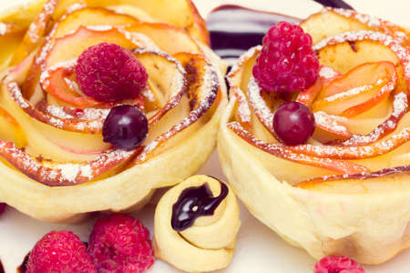 apple muffin with raspberry and blueberries on a white plate, drizzled with chocolate sauceの写真素材