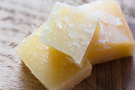 pieces of parmesan cheese on a wooden background