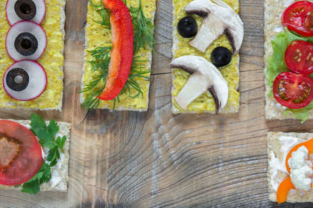 bruschettas with different vegetables on a wooden backgroundの写真素材