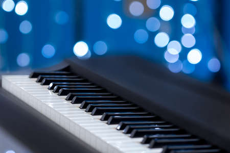 Piano keys side view with shallow depth of field on a blue bokeh backgroundの写真素材