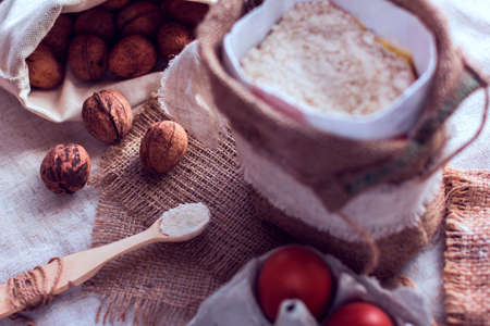 nuts in a sack , flour and a spoon with flour and eggs on a sackclothの写真素材