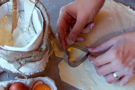 woman's hands cutting the dough with a mold