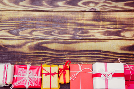 gifts in a different colorful packages on a wooden background