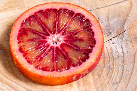 the juicy cut Sicilian orange on a wooden backgroundの写真素材