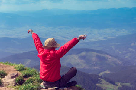 tourist with the opened and raised hands up on the background majestic mountainsの写真素材