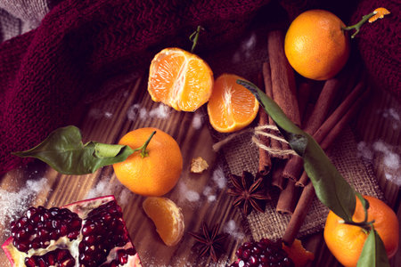 christmas warm still life consist of tangerines, pomegranate, cinnamon, anise and knitted sweater