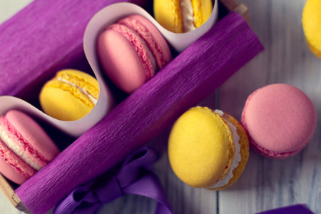 yellow and pink macaroons in a violet box with bow-knot