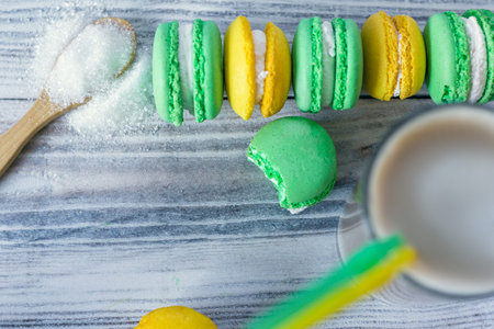 colorful macaroons are laid in a row and latte in a glass