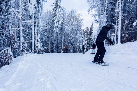 snowboarders descend down the mountainの写真素材