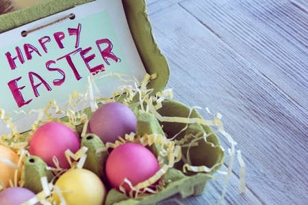 colorful easter eggs with inscription "Happy Easter" in a nestの写真素材