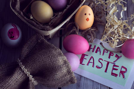 violet, pink and yellow easter eggs with a rabbit image and inscription "Happy Easter"の写真素材