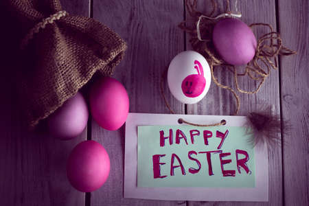 violet, pink and white easter eggs with a rabbit image and inscription "Happy Easter"の写真素材