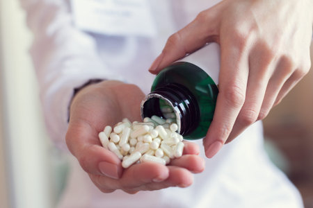 doctor pours out white pills from a bottleの写真素材