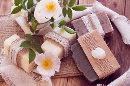 Decorated pieces of various dry soap with a roses on a wooden backgroundの写真素材
