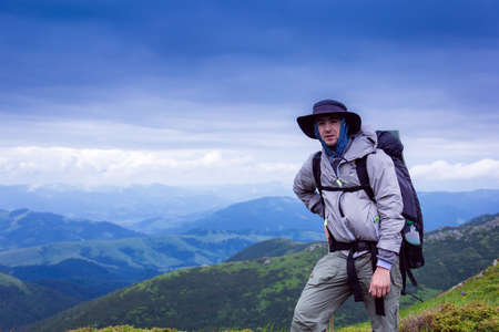 the hiker is stand at mountain top against the background of majestic mountainsの写真素材