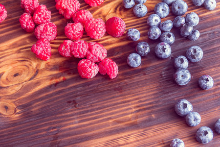 Raspberries and blueberries on a wooden backgroundの写真素材