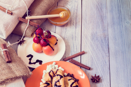 Breakfast  consisting of croissants, honey  and canapÃ©s of strawberries and apricots