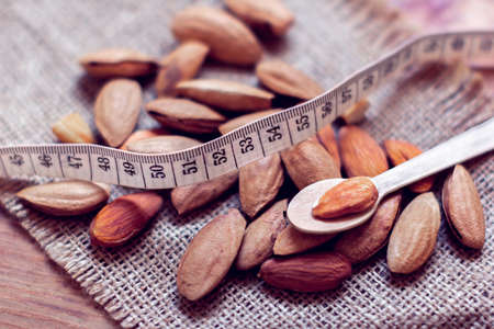 almond in a spoon with  tape measure on a sackclothの写真素材