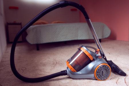 vacuum cleaner with orange color on a bedroom background