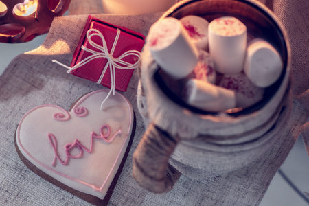 Cozy winter with gift, ginger snap in the shape of heart  and cup of coffee with marshmallow. Still...