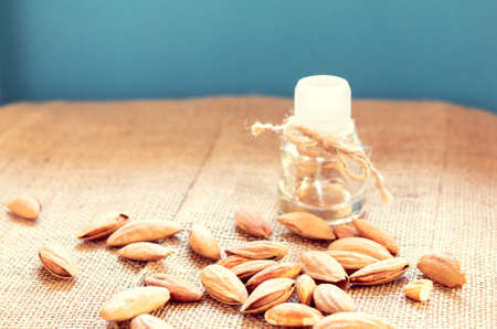 scattered almonds and bottle with an almond's oil on a sackclothの写真素材