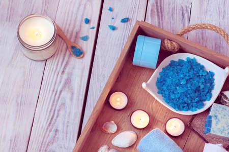 SPA consist from blue sea salt, soap and candles in a wooden trayの写真素材