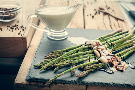 asparagus with sauce on a black boardの写真素材