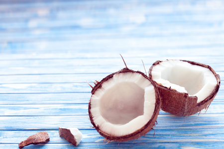 two half of coconut on a blue wooden background