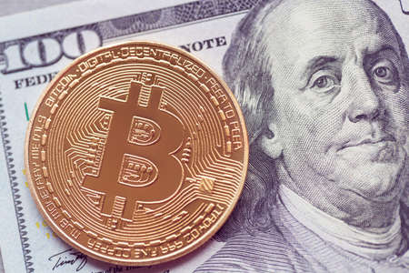 gold bitcoin lies on one hundred dollarsの写真素材