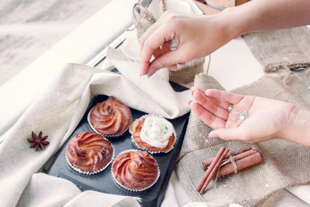 Women's hands decorate cupcakes