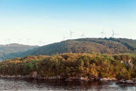 Alternative Energy Wind Turbines in the mountains on a sea and blue sky backgroundの写真素材