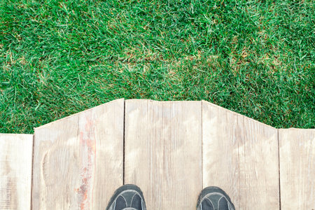 wooden dais with feet and green grass as a background