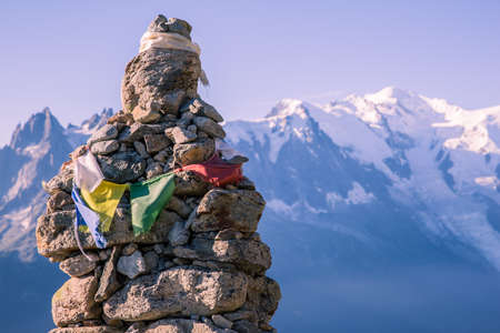 Altitude Cairn and Tibetan Flag in front of Iconic Mont-Blanc Snowy Peaks and Glacierの写真素材