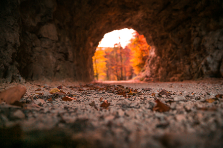 Stone Carved Tunnel and Red Sunset Light opening on Autumn Foliageの写真素材