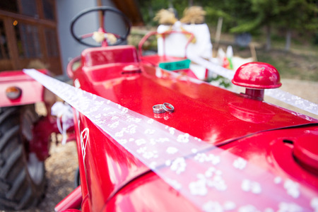 Wedding Rings on a Red Tractor in Rustic Wedding Decorationの写真素材
