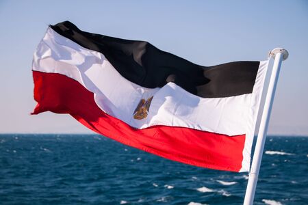 Egyptian Flag Floating in the Sun with Red Sea in the Backgroundの写真素材