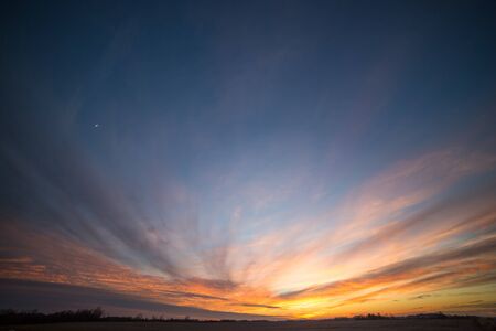 Partially Cloudy Dramatic Sunset Sky over Winter Fields and Meadowsの写真素材