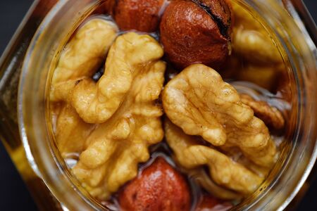 Delicious honey with walnuts and hazelnutsの写真素材