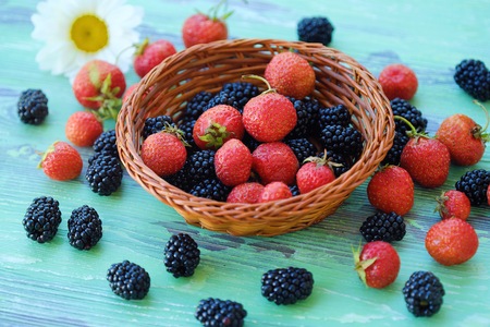 Blackberries and strawberries from the garden on a wooden backgroundの写真素材