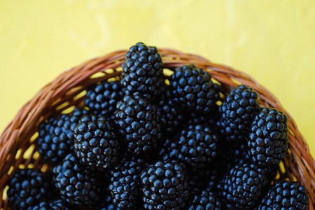 Delicious fresh blackberries in wooden basketの写真素材