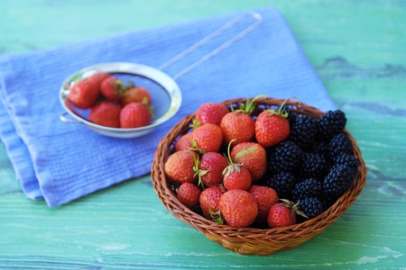 Blackberries and strawberries from the garden on a wooden backgroundの写真素材